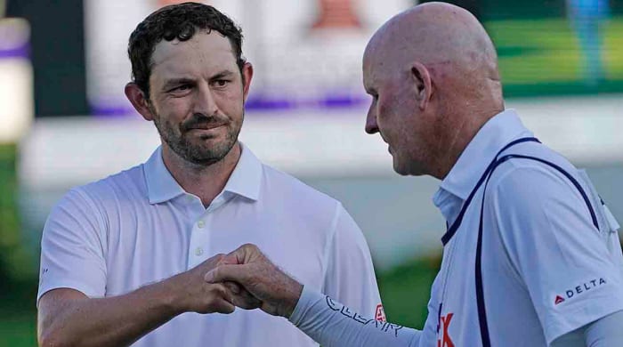 Patrick Cantlay, left, bumps fists with caddie Joe LaCava on the 18th green during the final round of the 2023 St. Jude Championship.
